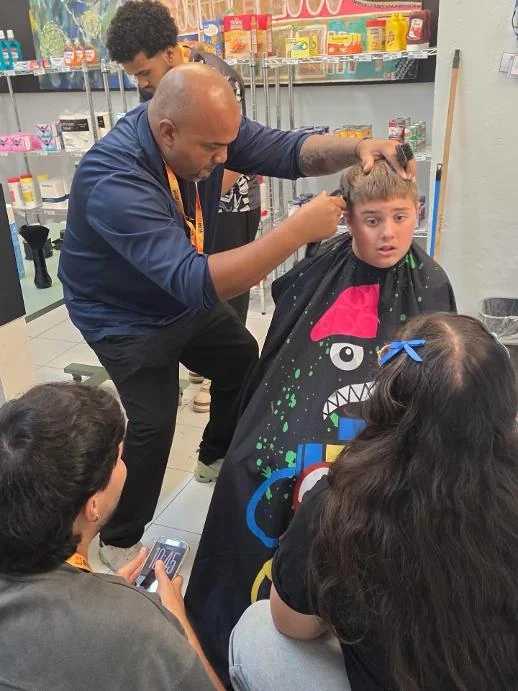 Prof. Orfy Sosa realizando una demostración con estudiantes de Barbería y Estilismo