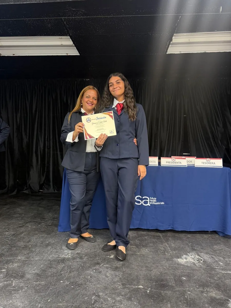Profa. Yokasta Guzmán durante un reconocimiento estudiantil de HOSA
